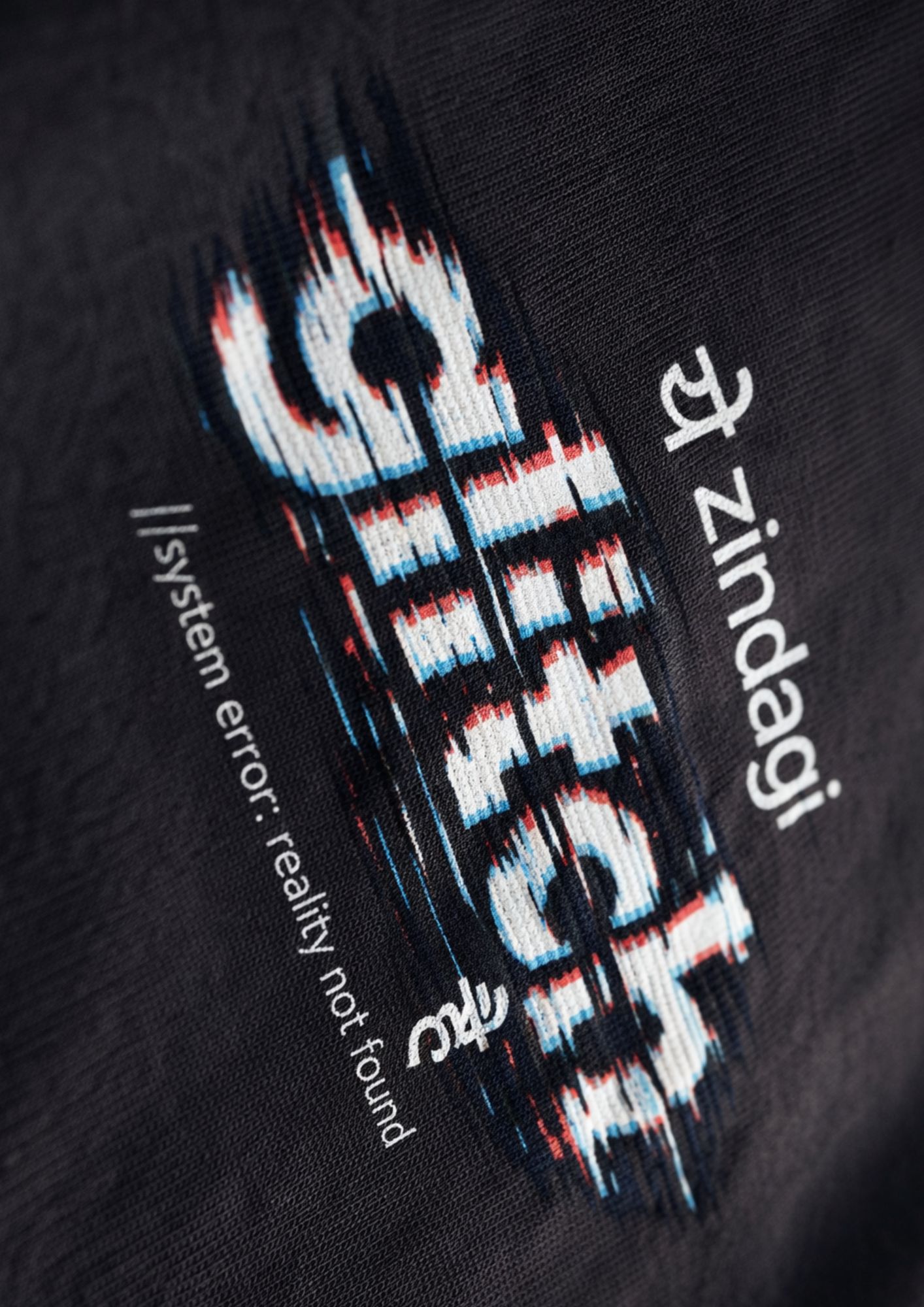 Male model wearing LUFIT oversized black t-shirt with graphic print, 240 GSM cotton fabric, styled with beige trousers in a minimal studio setting