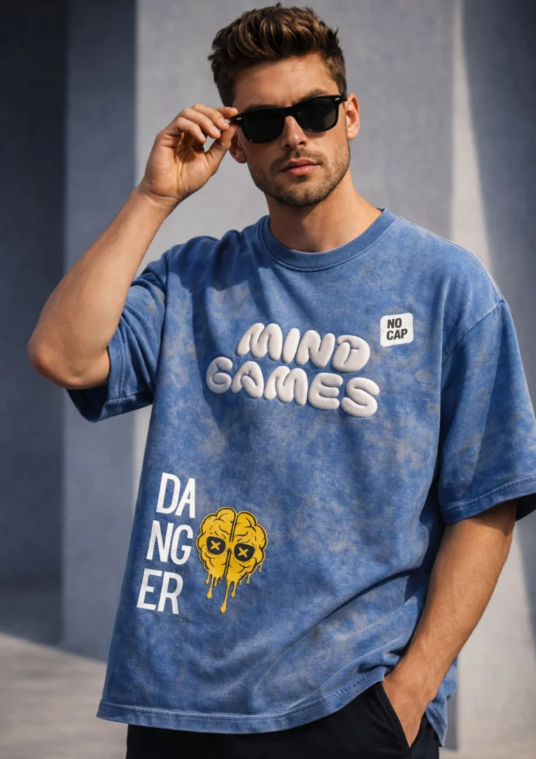 Oversized blue acid wash t-shirt with 3D puff print "Mind Games" graphic, "Danger" text, dripping brain illustration, and "No Cap" patch badge
