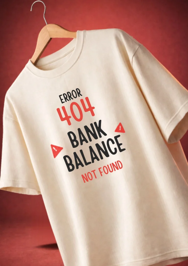 Cream oversized t-shirt with bold typography and red warning icons reading "Error 404 Bank Balance Not Found" hanging on a wooden hanger against a red background